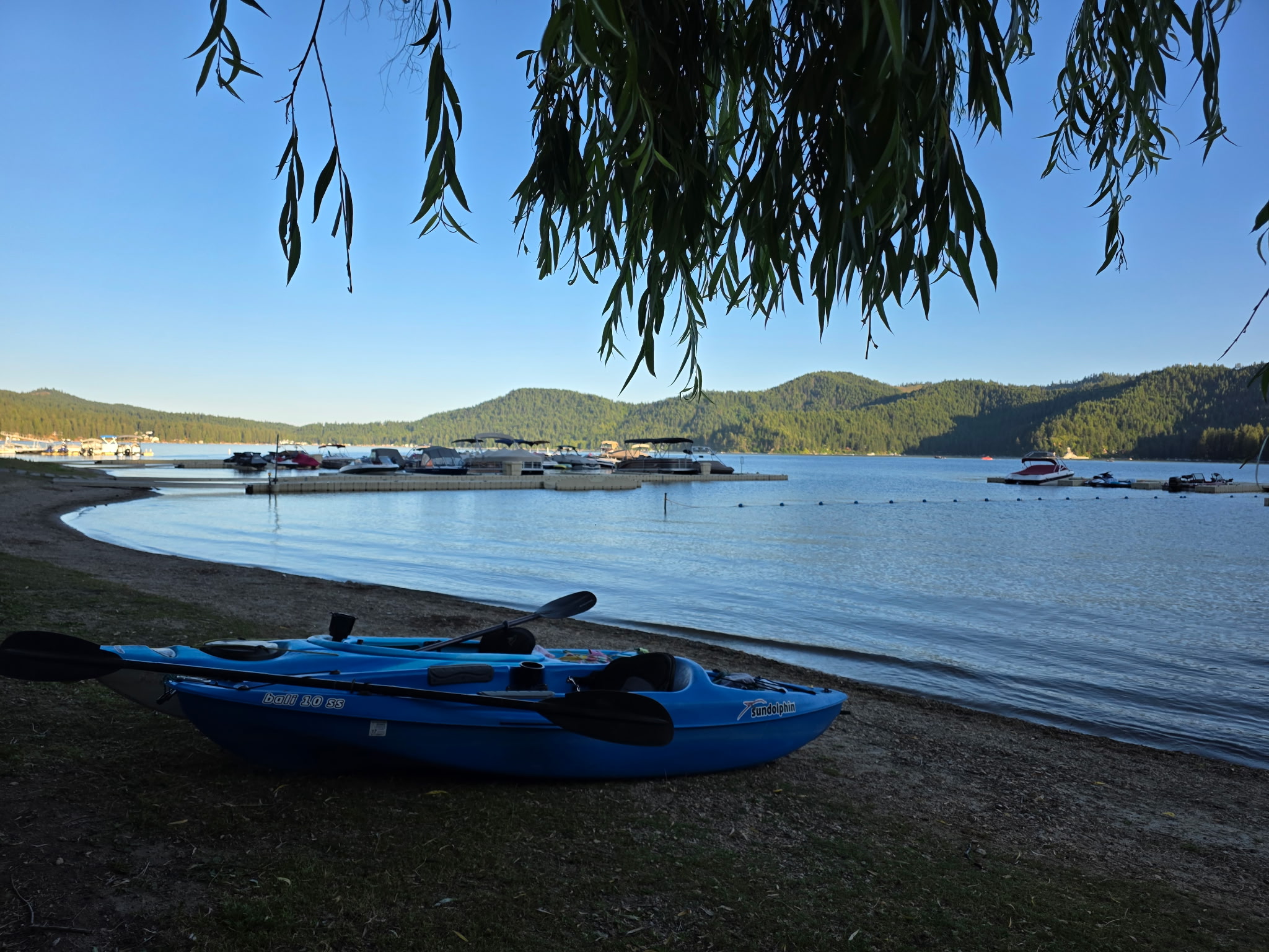 Blue kayaks on shore with lake and mountain views - Equipment rentals available