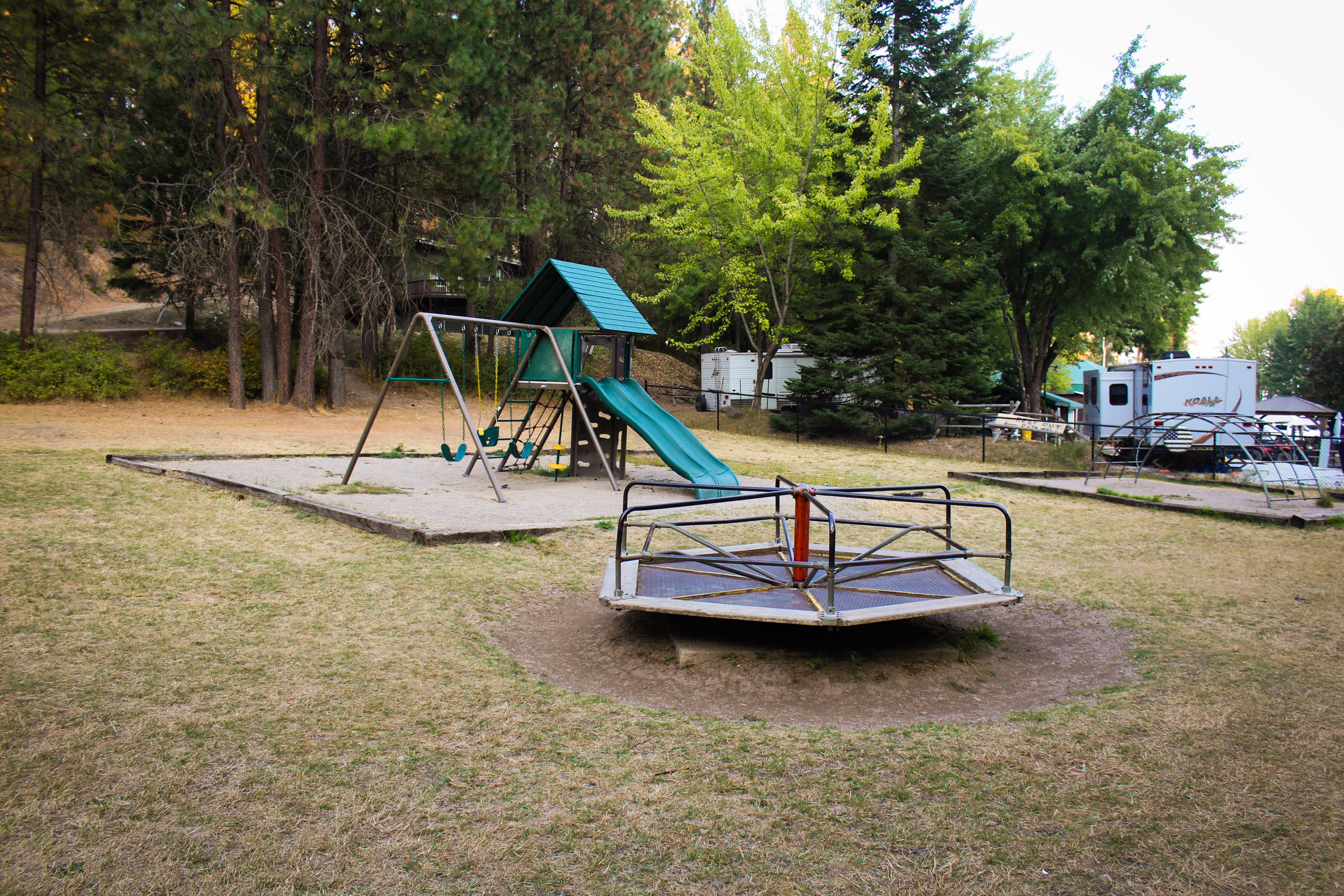 Children's playground with swings, slide and merry-go-round among RV sites